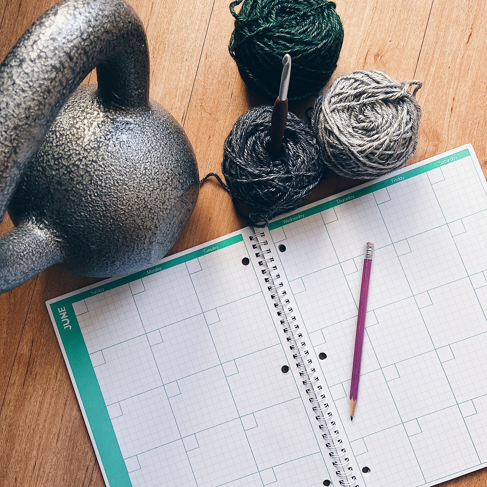 picture of a planner with yarn a crochet hook and kettle bell