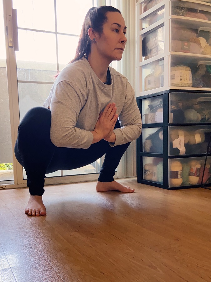 squat with prayer arms to open the hips and release low back tightness